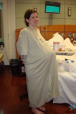 A pregnant woman standing in the hospital.