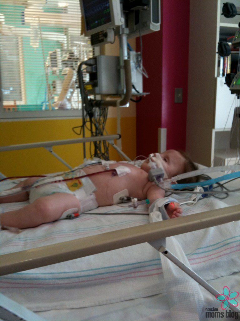 A baby on a hospital bed connected to many tubes and wires. Logo: Houston moms blog.