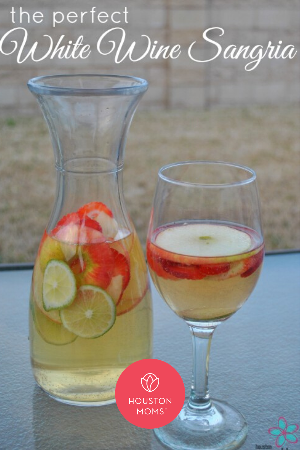 The Perfect White Wine Sangria. A pitcher and glass of white sangria with limes, strawberries, and apples. Logo: Houston moms blog. 