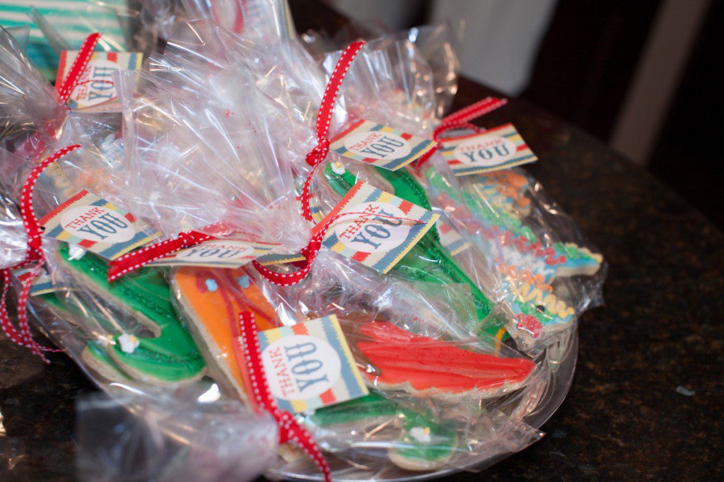 A basket of frosted cookies wrapped in cellophane with attached thank you cards. 