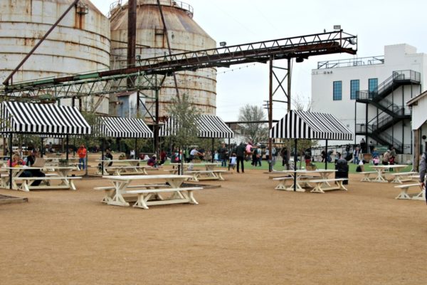 Picnic benches with two silos in the background. 