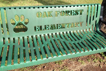 A park bench with the text Oak Forest Elementary.