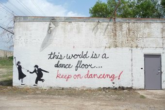 A mural with the text This world is a dance floor... Keep on dancing!