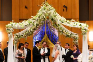A photograph of a man and a woman getting married at a synagogue. 
