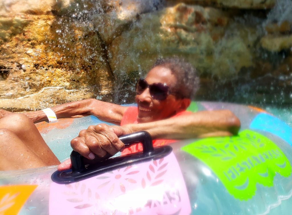 A smiling person in a tube at a waterpark. 