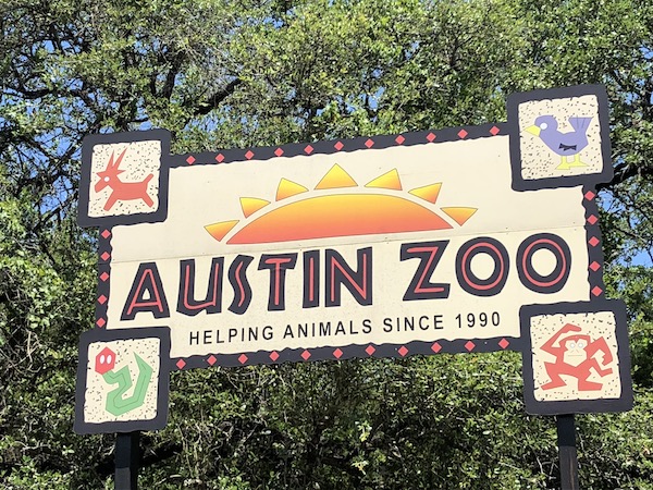 Sign for the Austin Zoo. Helping animals since 1990. 