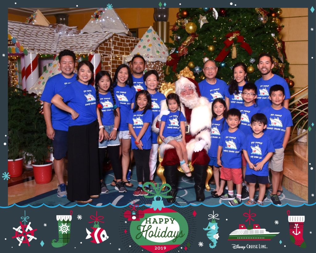 A photograph in a Disney Cruise Line Happy Holidays frame of 8 adults and 8 children posing with Santa. 