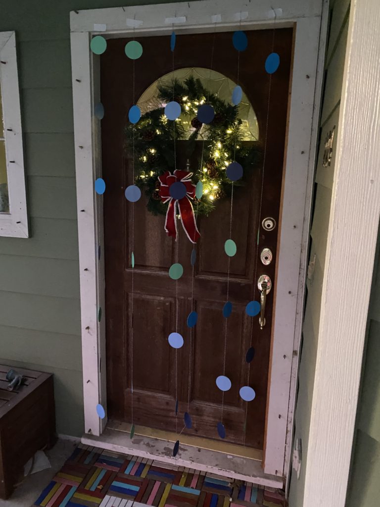 A front door decorated with garland. 