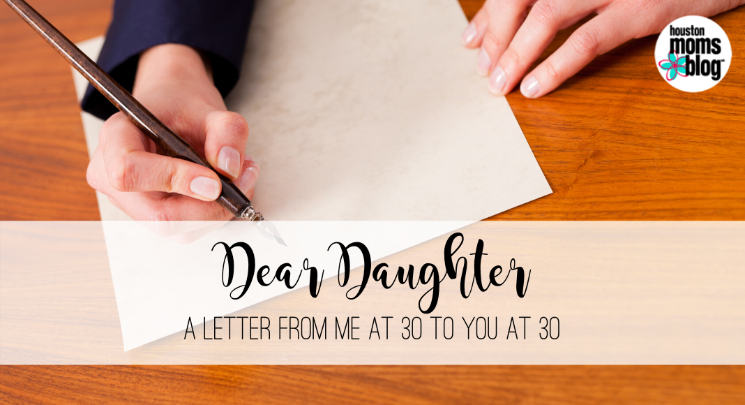 Dear Daughter: A Letter From Me At 30 To You At 30. Logo: Houston Moms blog. A photograph of a person holding a pen over a piece of paper.
