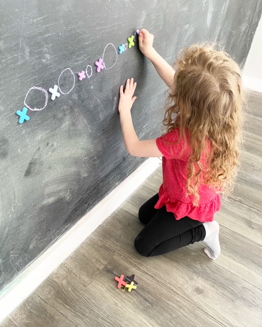 girl drawing on chalkboard wall