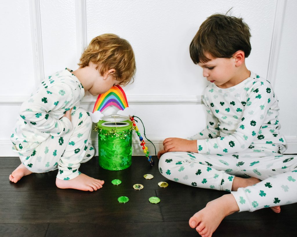 boys in shamrok pajamas crouch beside their trap