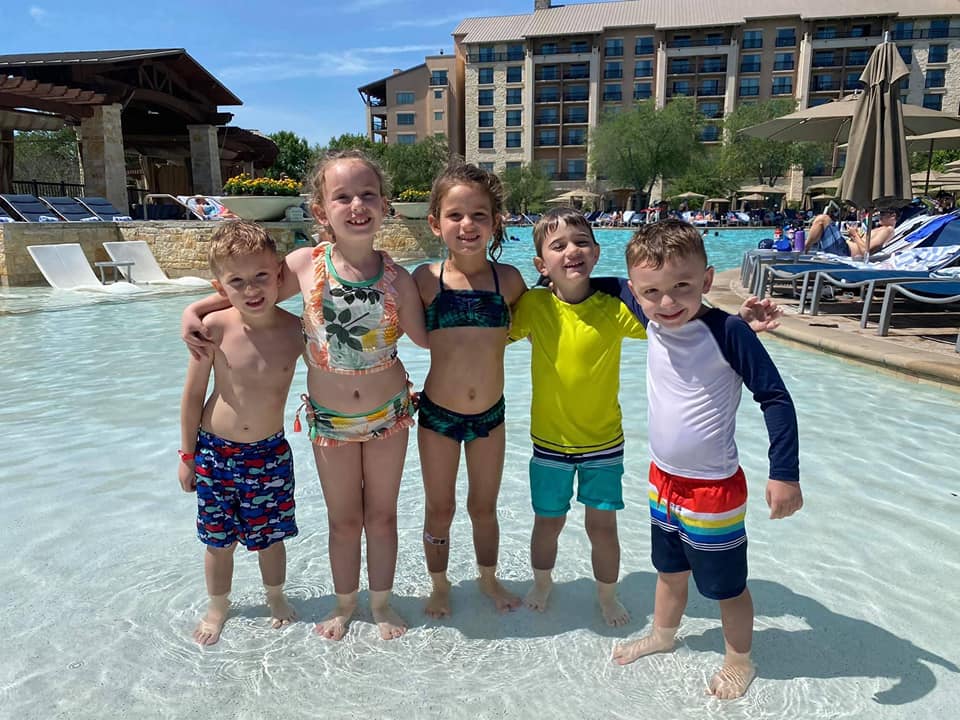 Five young children standing in a pool at J W Marriott. 