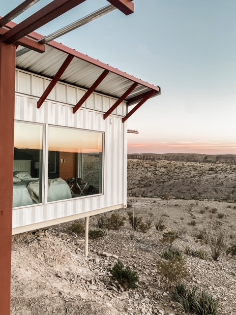 A home with large windows in a desert space. 