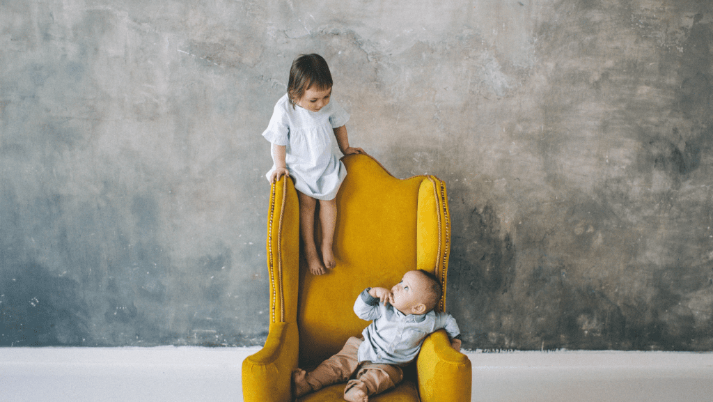 Two young children on a chair. 
