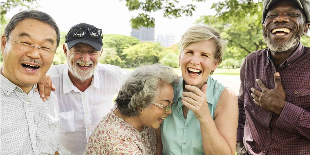 A group of five older adults laughing