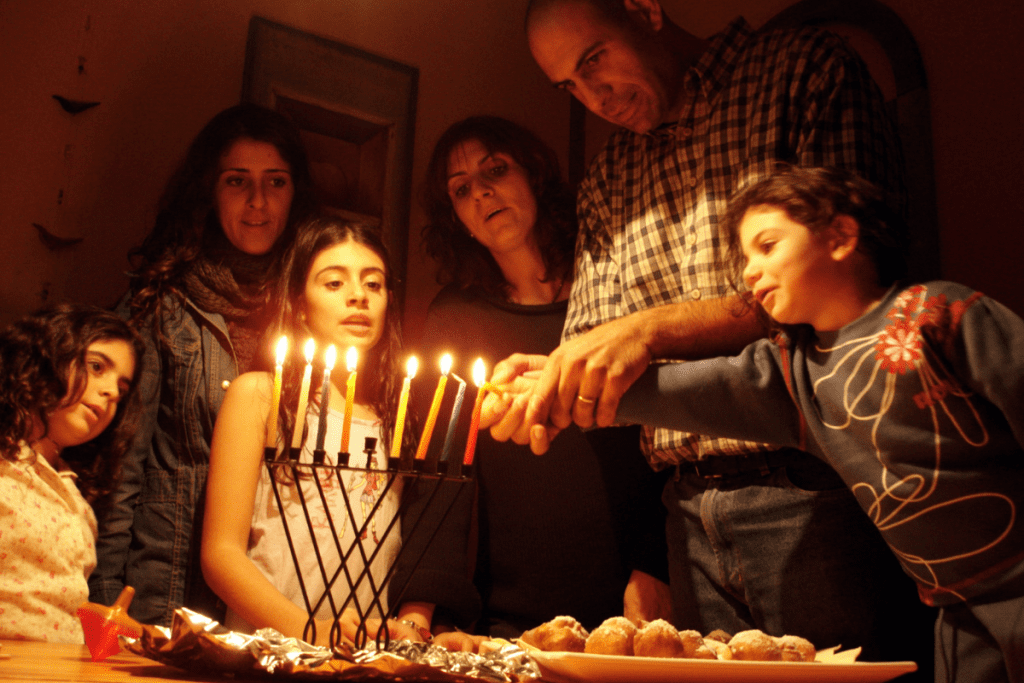 family gathered around a menorah