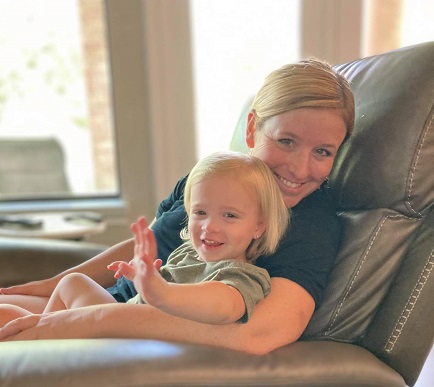 Stay at home mom cuddling toddler on recliner