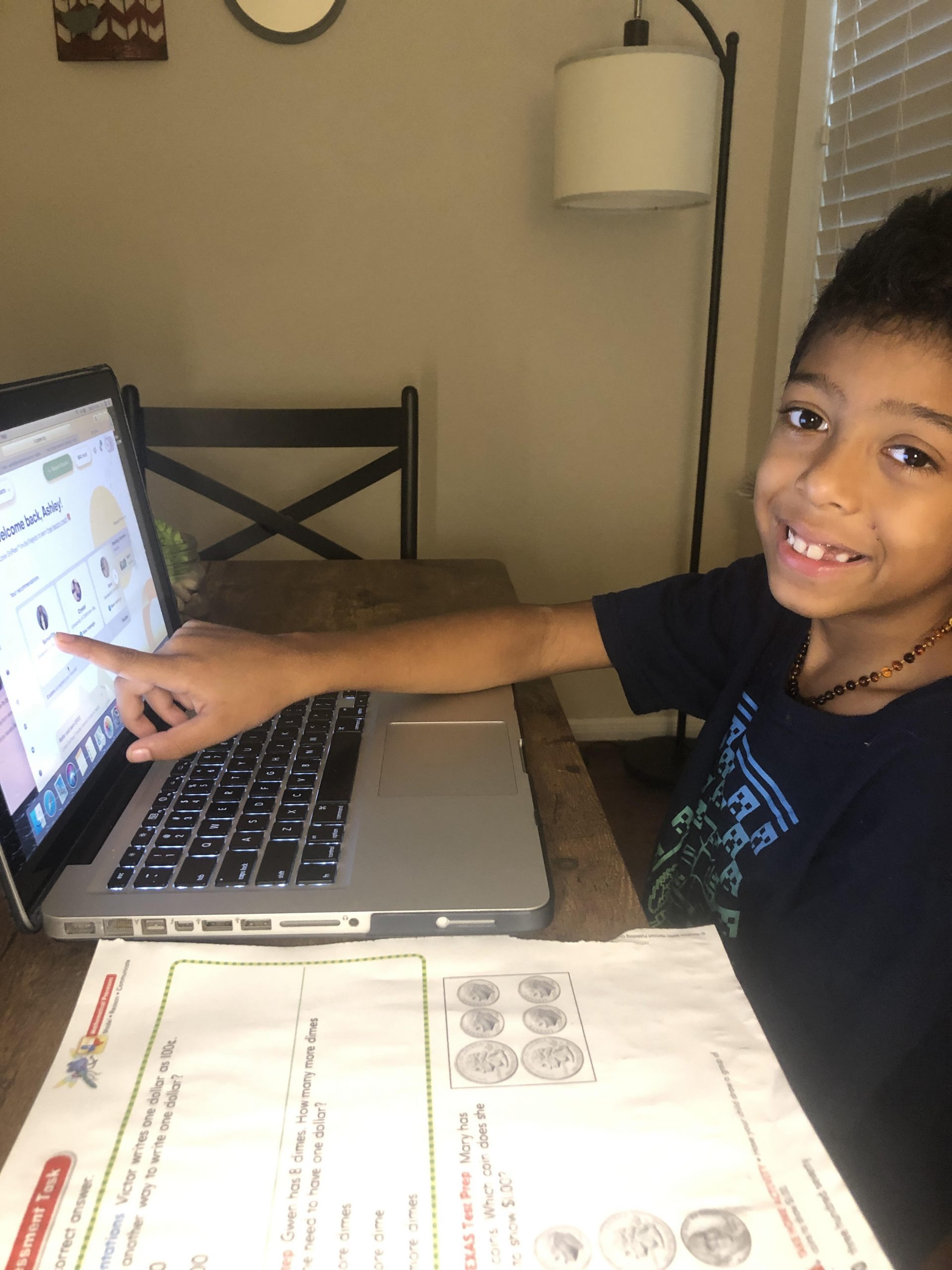 Young boy pointing to GoPeer screen on laptop