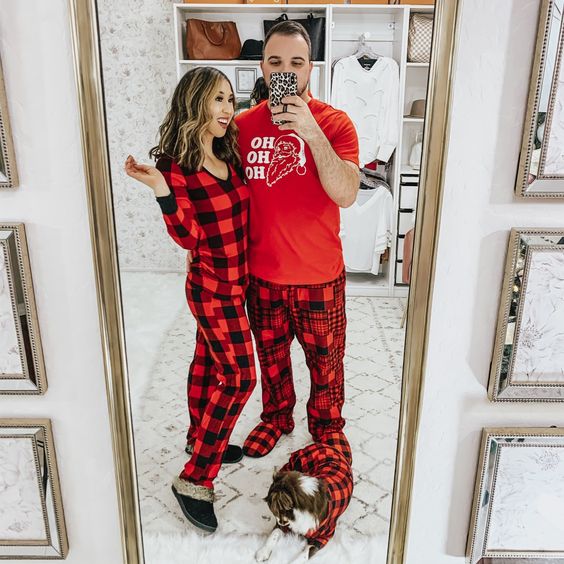 couple posing in matching family pajamas that are buffalo plaid