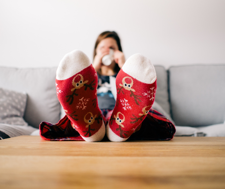 woman sitting watching Hallmark movie with feet propped up on table
