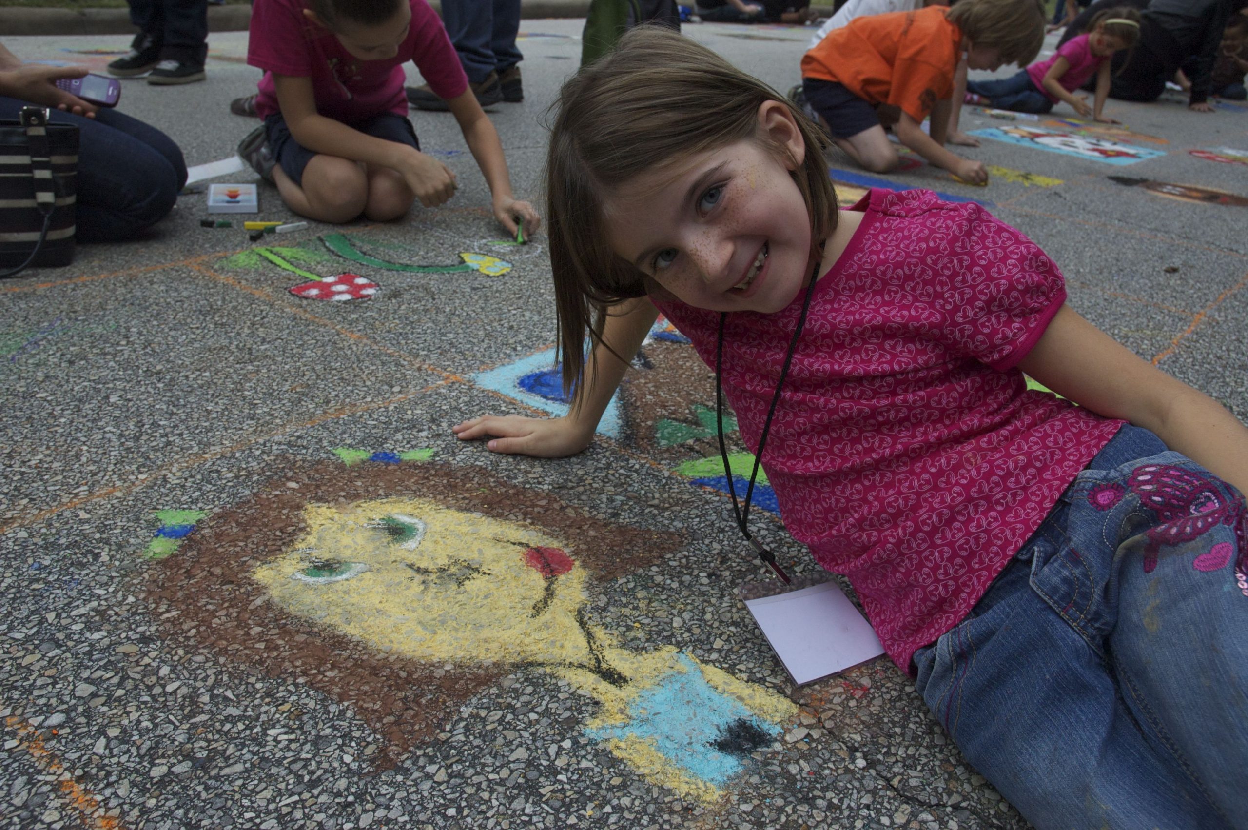 young girl beside a chalk art self portrait