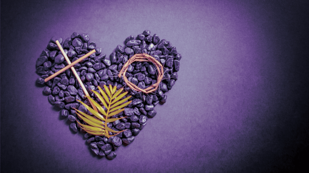 Heart for Lent made of small purple stones with a cross made of sticks and leaf on top