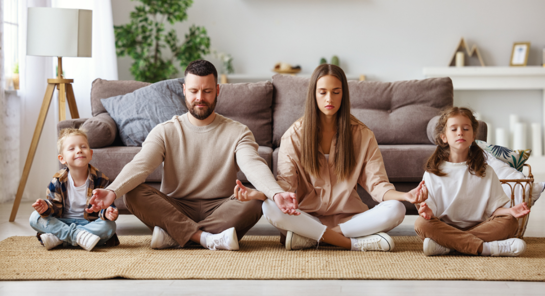 Family doing a meditation practice on floor of living room