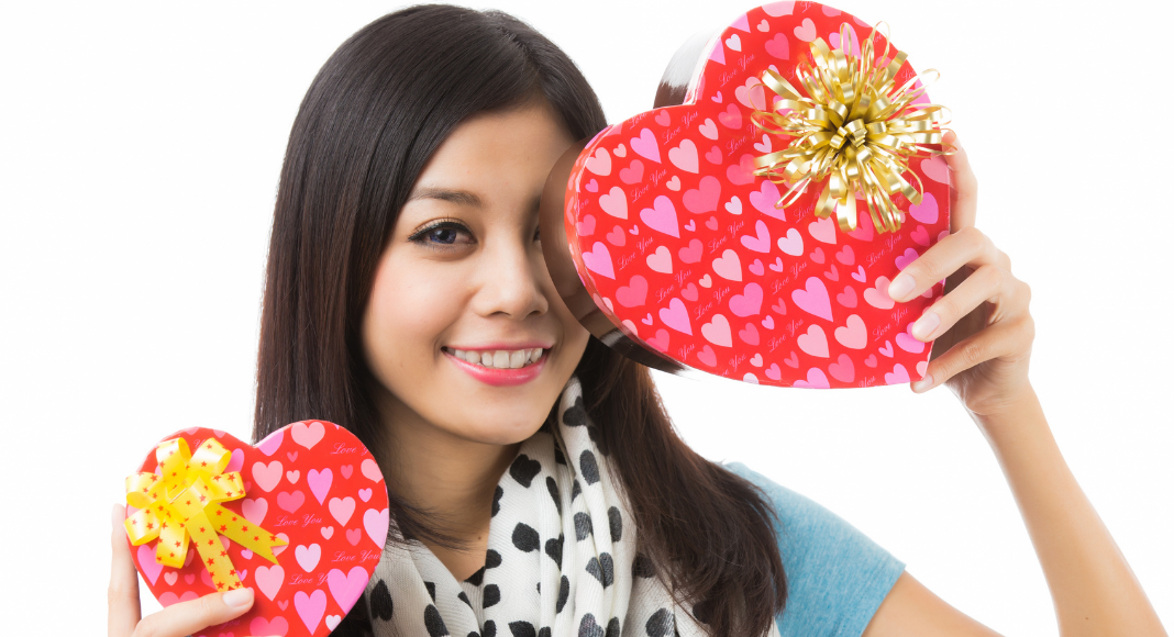 woman showing self-love holding two heart-shaped boxes