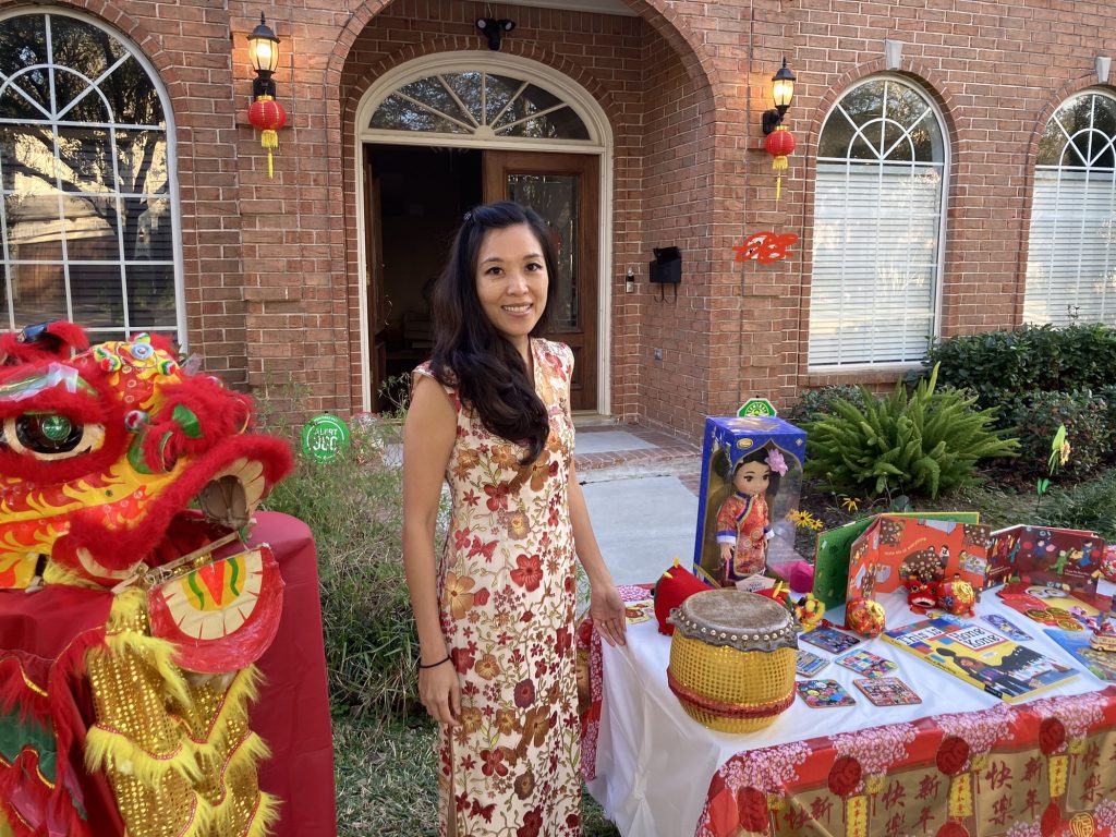 woman stands in front of house with Chinese New Year display in lawn