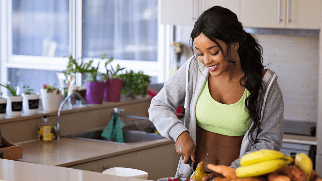 woman cutting fruit at kitchen counter