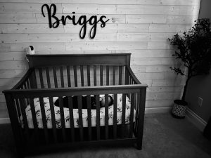 baby crib with name "Briggs" above it in wooden letters