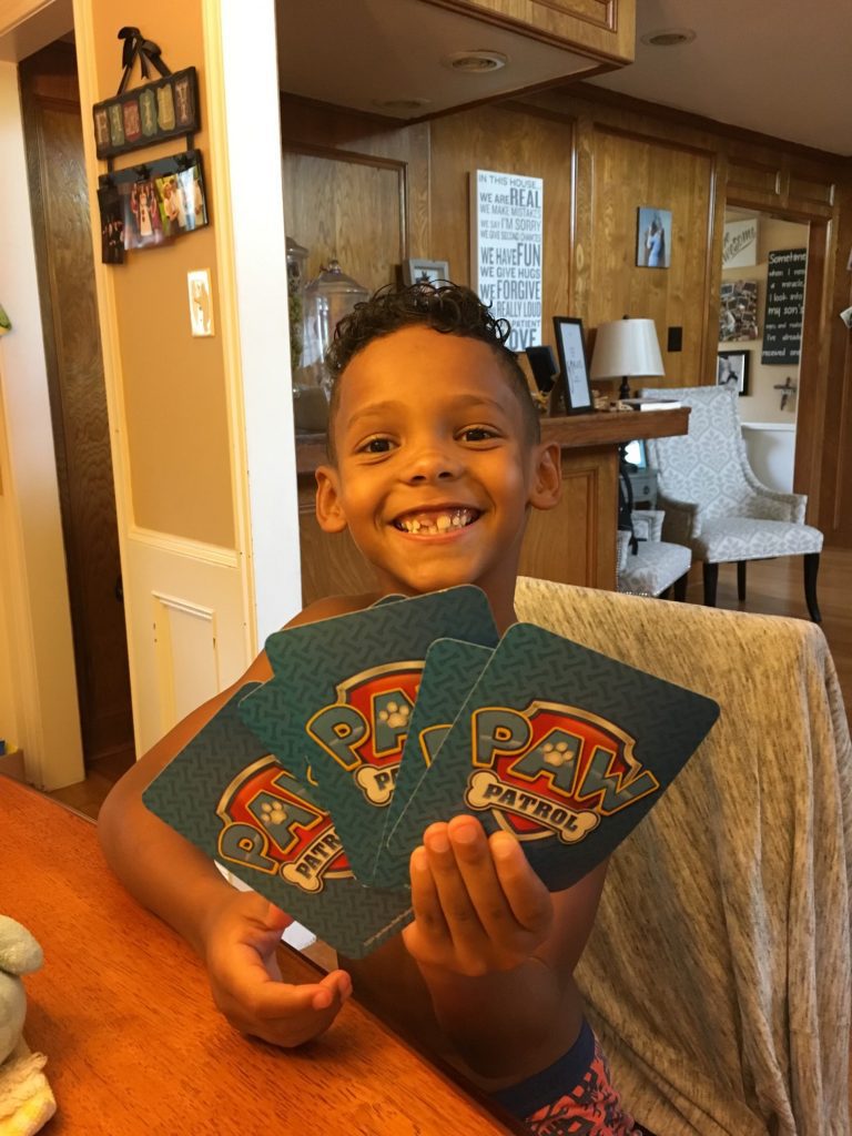 Young boy holds Paw Patrol game cards