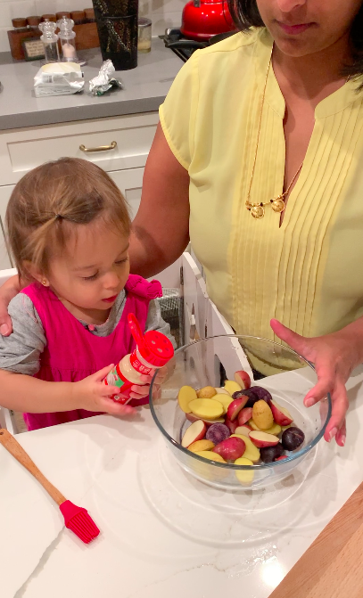 woman presents her toddler with a bowl of fruit