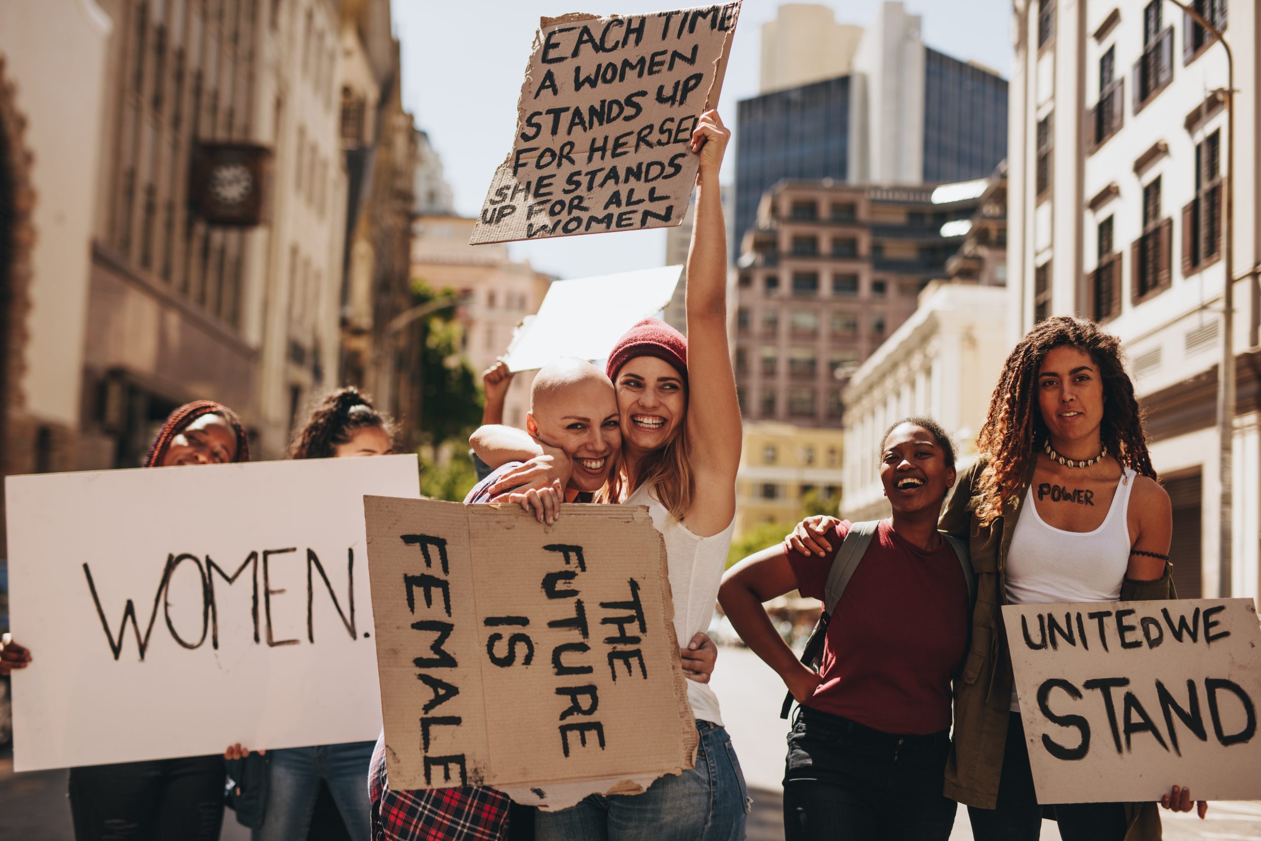 group of women hold signs about women's progress