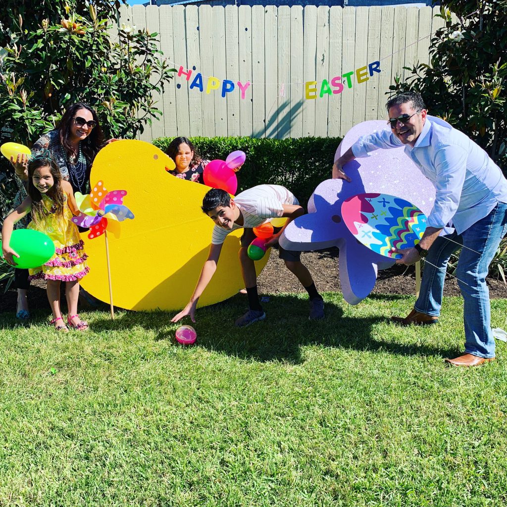family poses with easter decorations in yard