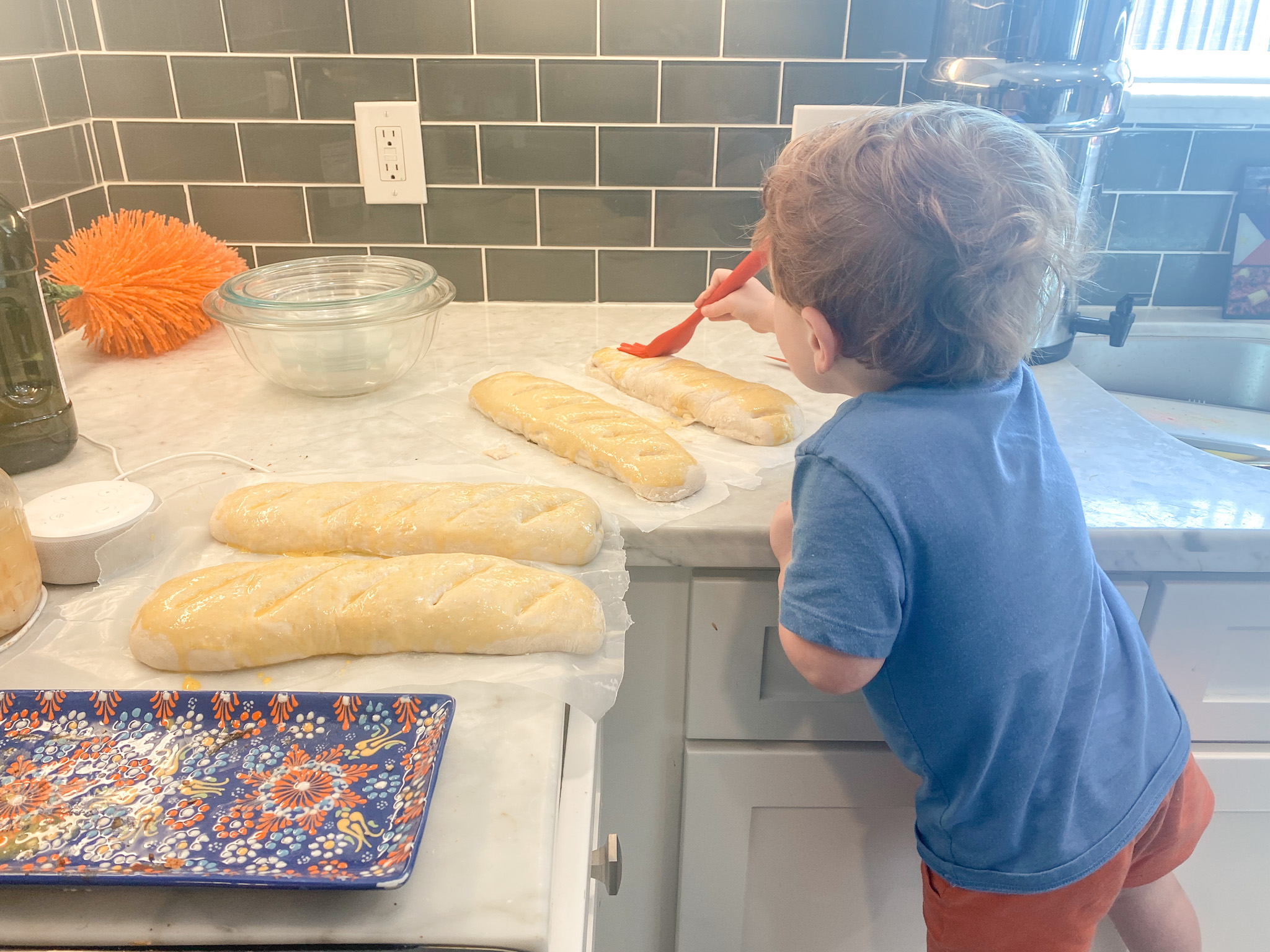 toddler buttering bread on counter