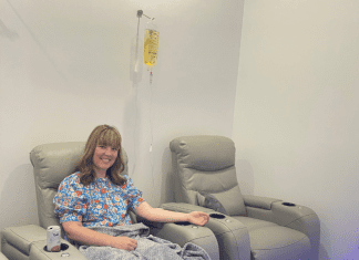 woman sits in chair receiving IV therapy