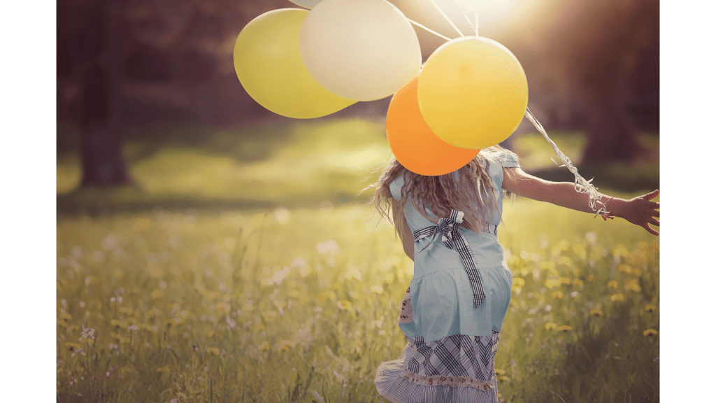 woman with balloons runs through field