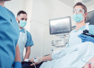 woman under anesthesia surrounded by medical professionals