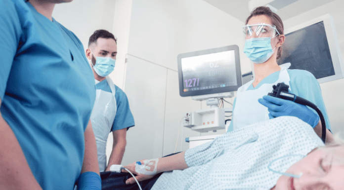 woman under anesthesia surrounded by medical professionals