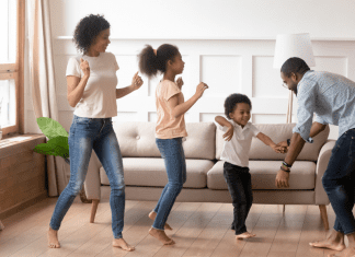 family of four dancing in living room