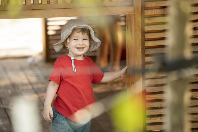 child with hat in play fort