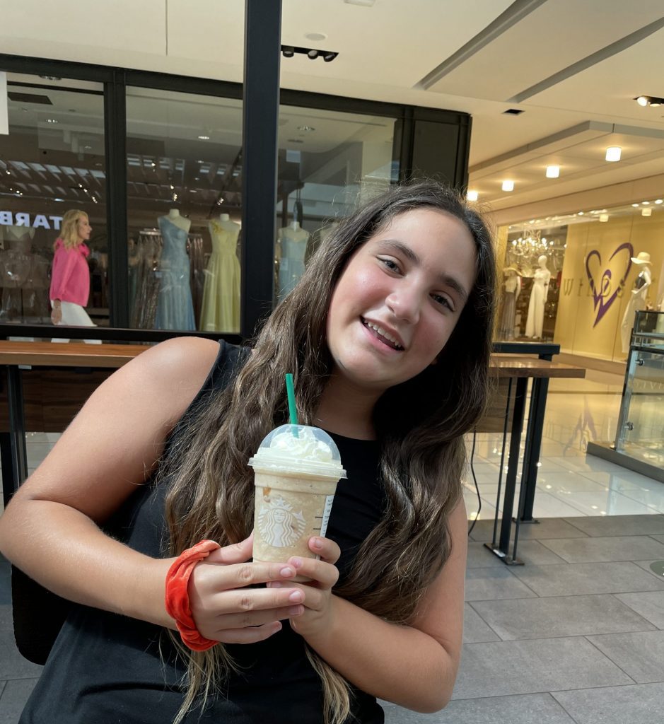 teenager holds a Starbucks drink