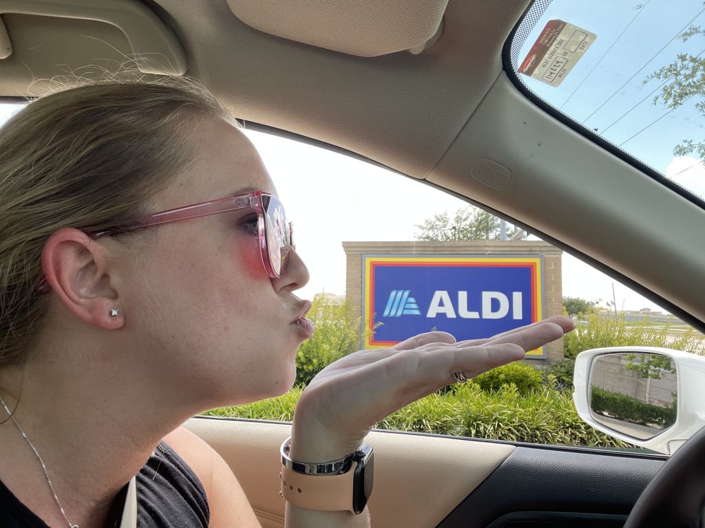 woman in car blowing a kiss at ALDI