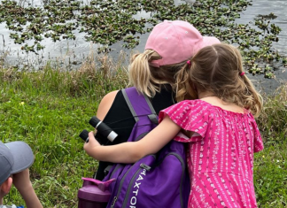 daughter embraces mother beside a lake