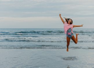 girl leaping in front of ocean