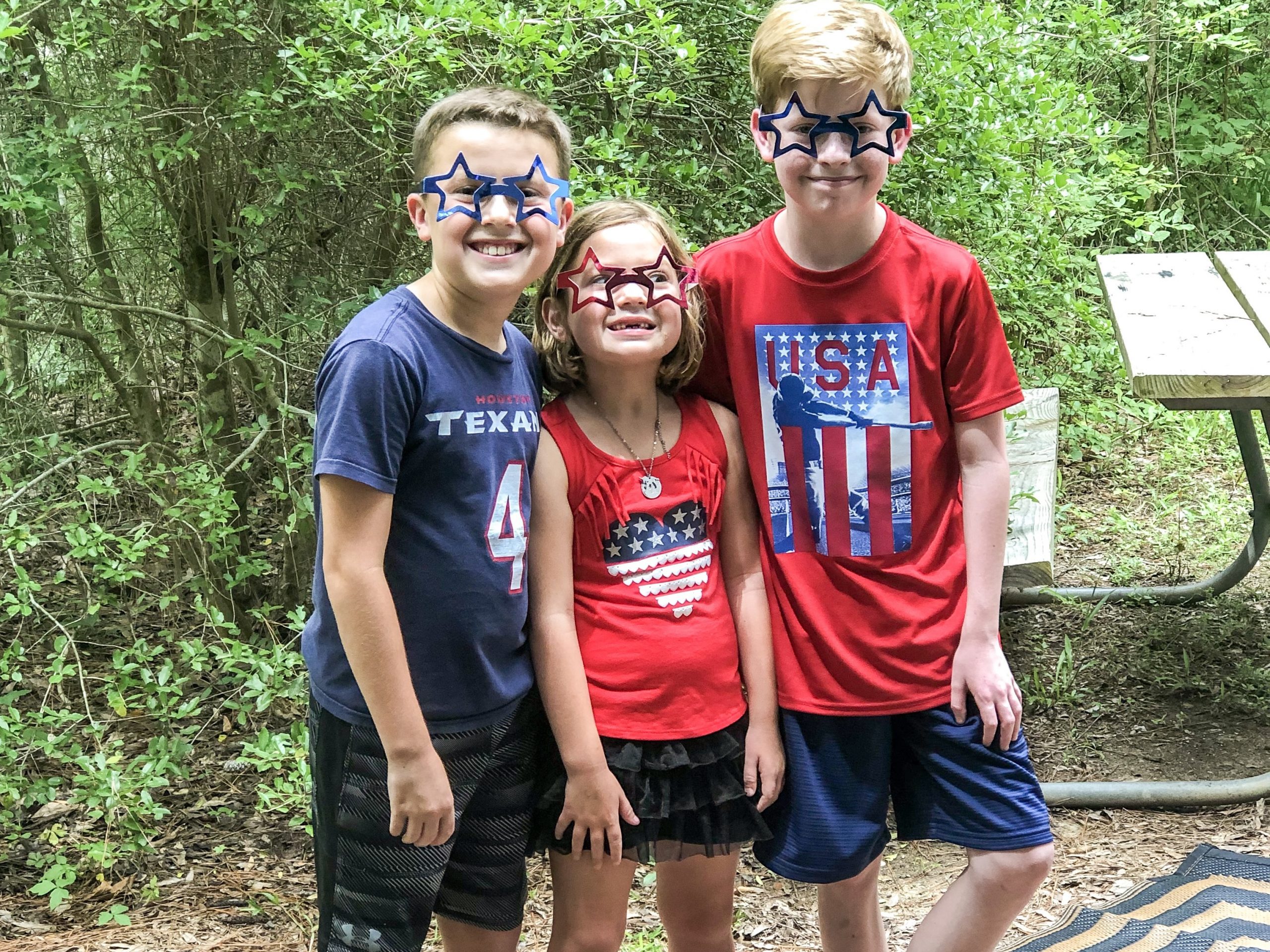 three kids in red white and blue with plastic star glasses 