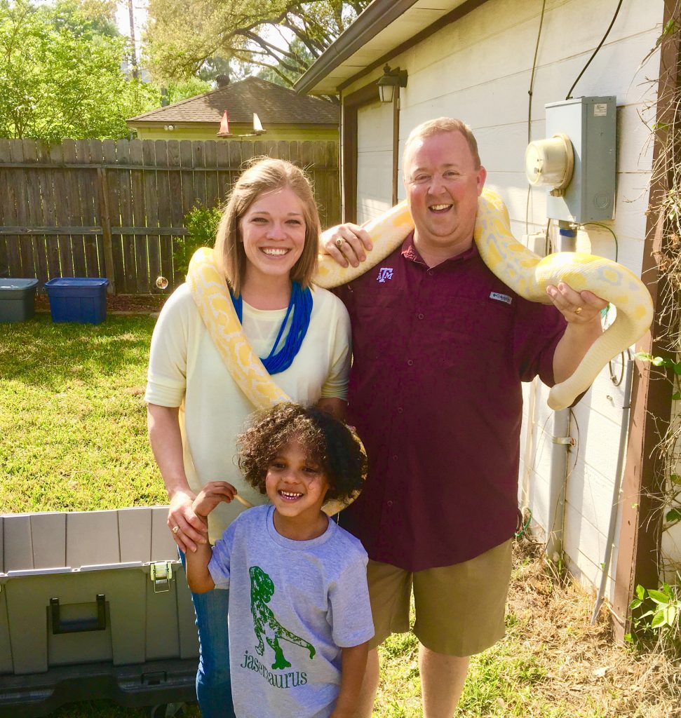 parents and son pose with giant snake