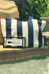 striped pool bag with a sign that reads "To the pool"