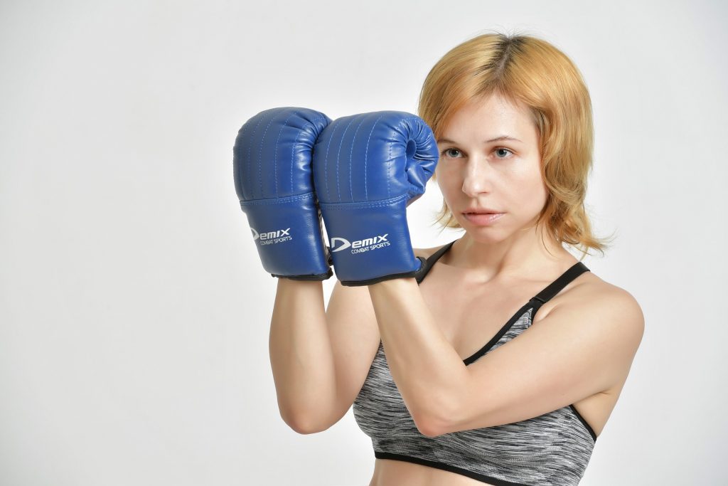 woman poses with boxing gloves